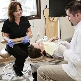 Patient lying in dental chair with dentist